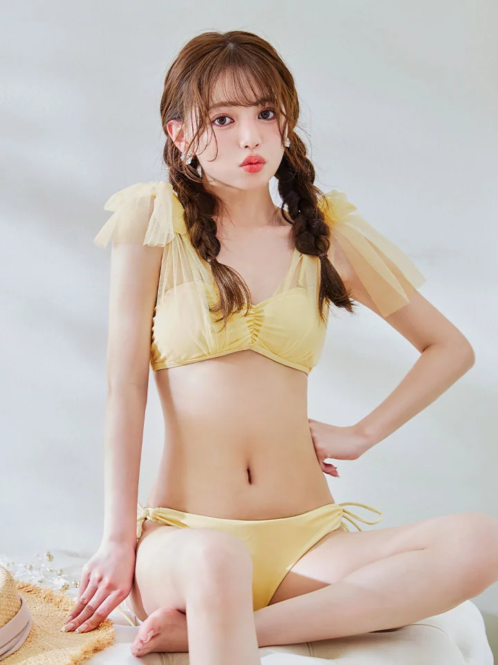 穿黄色泳装的女性坐在浅色座椅上